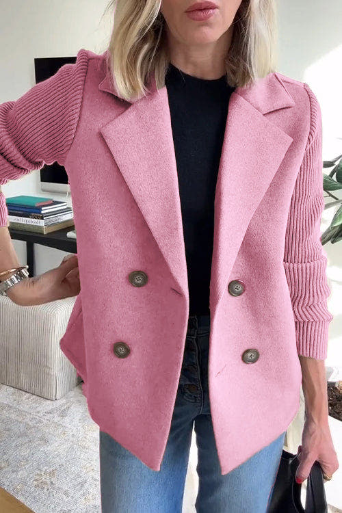 Person wearing a pink blazer with a blurred indoor background