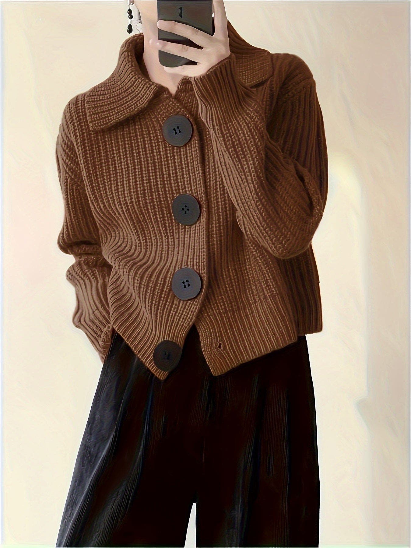 Brown knitted cardigan with buttons worn by a person, against a plain background